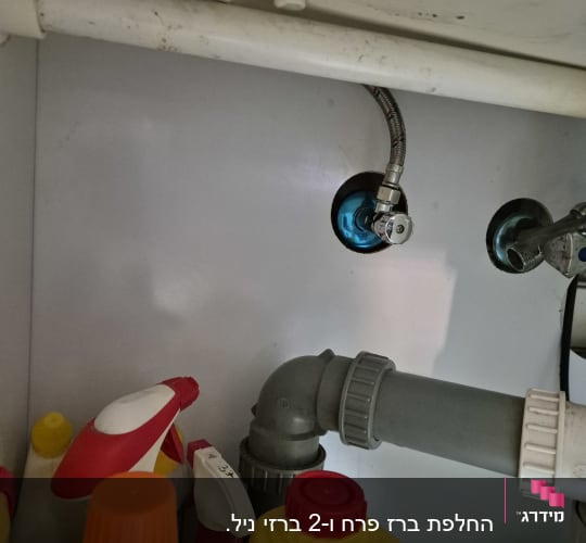 צינור פלסטיק אפור מתחת לכיור עם חיבורים